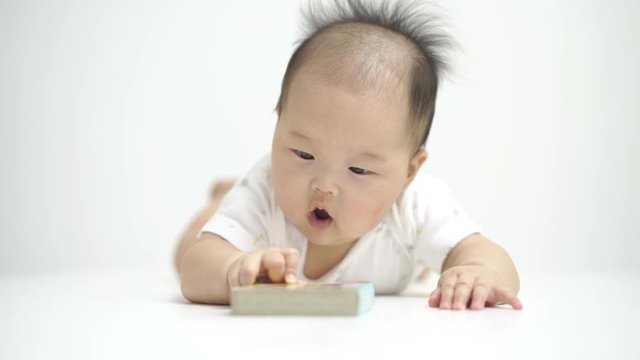 Asian chinese baby reading a cute little tiny book. 