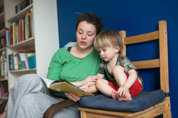 Mother reading with her son at home, casual,