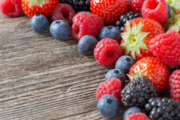 wooden background with fresh berries and mint, selective focus