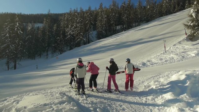 Young teenage girls with instructor prepares for skiing and have fun time on sunny winter morning.
