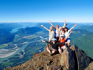 Group of Happy Friends Cheering on Mountain Top. British Columbia, Canada. 