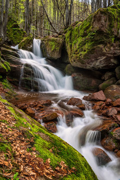 Springtime view of a waterfall among red rocks in Balkan Mountains, Bulgaria