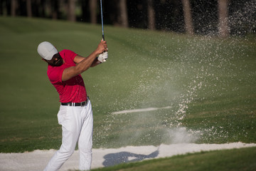 golfer hitting a sand bunker shot