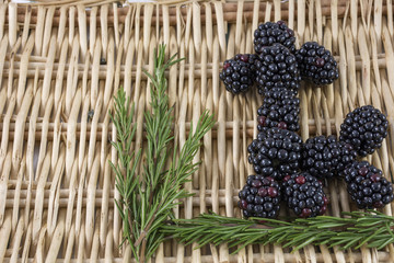 Blackberries in a form of a poodle with rosemary on the wicked mat