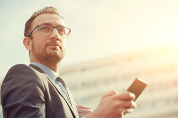 Urban guy using cellphone outdoors.