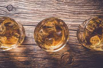 Glasses of whiskey on an old wooden table