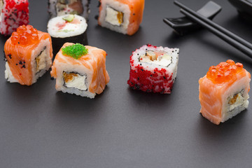 Japanese cuisine. Set of sushi mix roll with differen fresh ingredients over black background ( table ).
