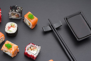 Japanese cuisine. Set of sushi mix roll with differen fresh ingredients over black background ( table ).