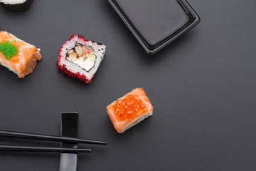 Japanese cuisine. Set of sushi mix roll with differen fresh ingredients over black background ( table ).