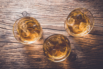 Glasses of whiskey on an old wooden table