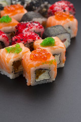 Japanese cuisine. Set of sushi mix roll with differen fresh ingredients over black background ( table ).