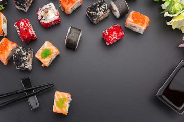 Japanese cuisine. Set of sushi mix roll with differen fresh ingredients over black background ( table ).