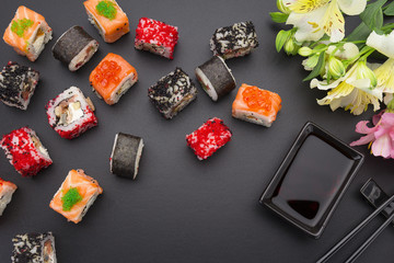 Japanese cuisine. Set of sushi mix roll with differen fresh ingredients over black background ( table ).