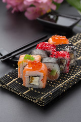 Japanese cuisine. Set of sushi mix roll with differen fresh ingredients over black background ( table ).