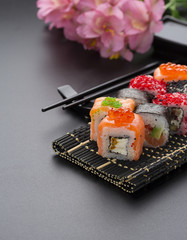 Japanese cuisine. Set of sushi mix roll with differen fresh ingredients over black background ( table ).