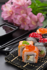 Japanese cuisine. Set of sushi mix roll with differen fresh ingredients over black background ( table ).