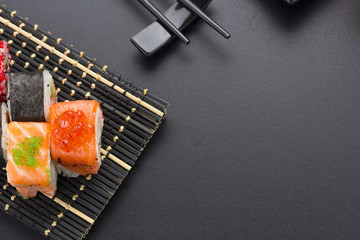 Japanese cuisine. Set of sushi mix roll with differen fresh ingredients over black background ( table ).