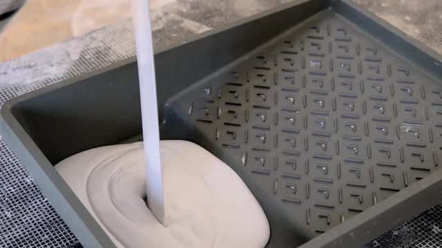 Preparing for painting, pouring paint from bucket into a paint tray slow motion