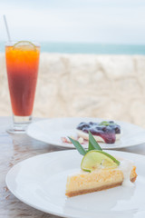 Lemon cheese cake in front of blueberry cheese pie and tea with lemon