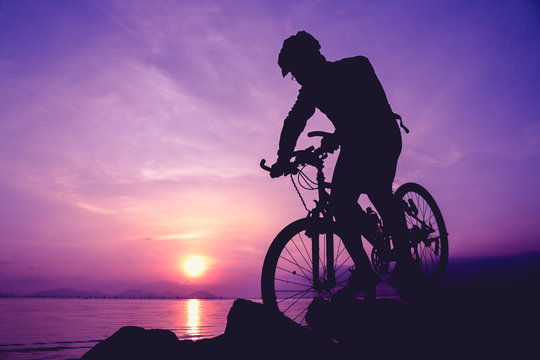 Healthy lifestyle. Silhouette of bicyclist riding the bike at seaside
