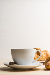 Croissants with cup of coffee on wooden background