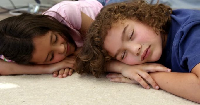 Brother and sister sleeping on the floor