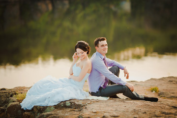 Happy bride and groom celebrating wedding day. Married couple sitting together