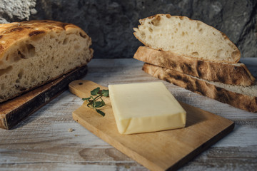 Pieces of rustic round loaf bread with butter