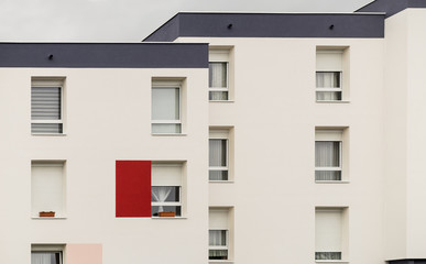 Fassade eines modernen Wohnblocks mit Flachdach einfachen PVC Fenstern und Rollläden