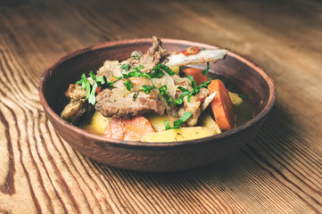 mutton stew on the wooden table, rustic style