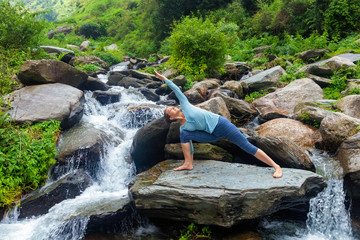 Fototapeta na wymiar Woman practices yoga asana Utthita Parsvakonasana outdoors