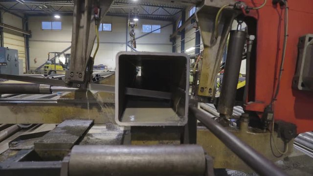 Closer look of the machine metal sawer with water dripping out of the machine while cutting