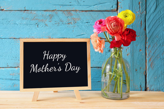 flowers next to blackboard, on wooden table