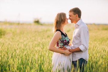 pretty pregnant with her husband in the field