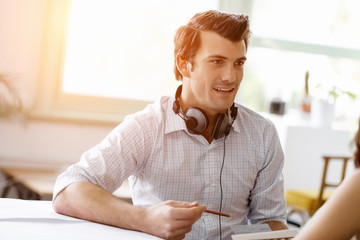 Young man in office talking to his colleague