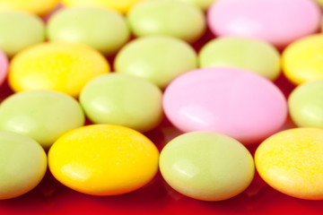 colored pills on a red background close-up macro