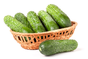 cucumbers in a wicker basket isolated on white background