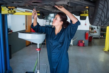 Female mechanic servicing a car
