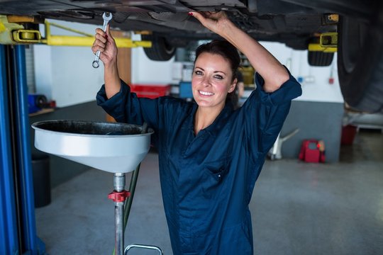Female mechanic servicing a car