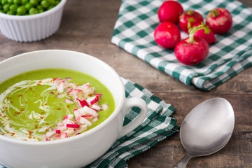 Peas cream with radishes on rustic wooden table
