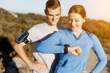 Runner woman with heart rate monitor running on beach