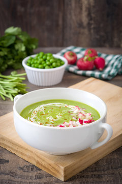 Peas cream with radishes on rustic wooden table

