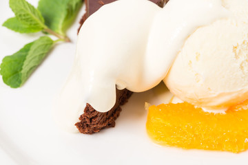 Chocolate cake with ice cream scoop closeup.