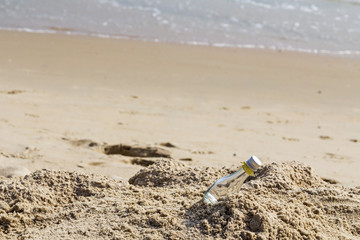Fototapeta na wymiar Empty glass bottle on the beach with copy space