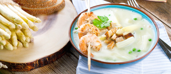Frische Spagelcreamsuppe serviert mit garnellenspies 