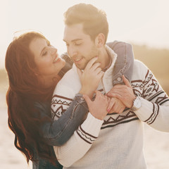 Lovely young couple on the sunset beach, selective focus and toned image