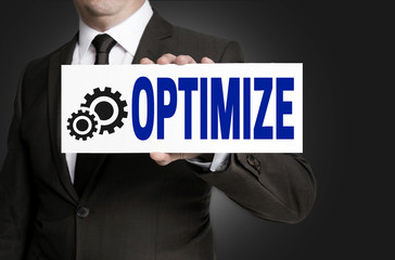 optimize sign is held by businessman background