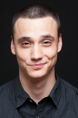 Fototapeta premium Smirking funny face portrait, young adult boy.