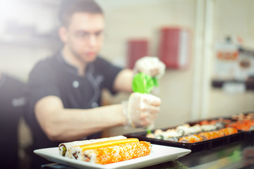 male cooks preparing sushi in the restaurant kitchen.