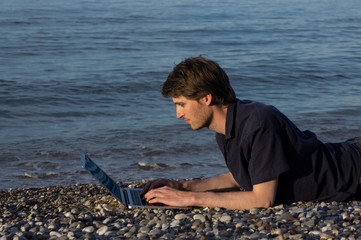 Man and laptop at the beach